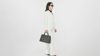 women holding black PREDOMINI City handbag against a white background